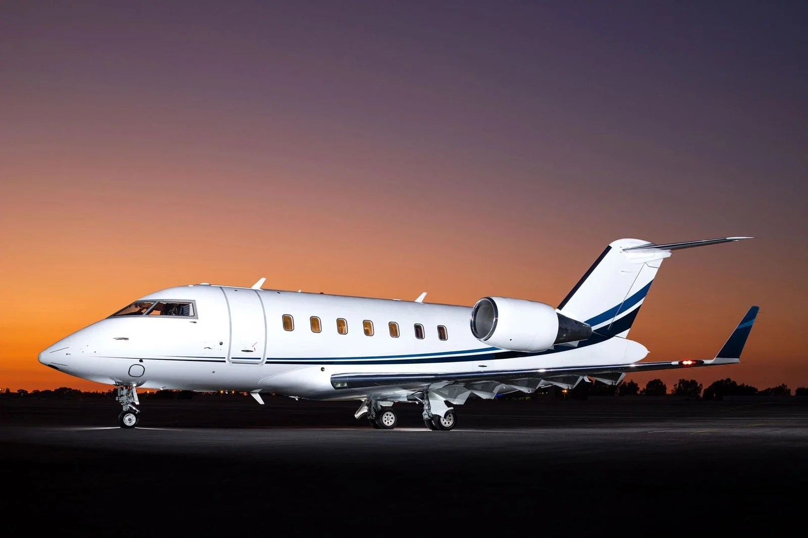 Bombardier Challenger 605 jet parked on the apron at dusk