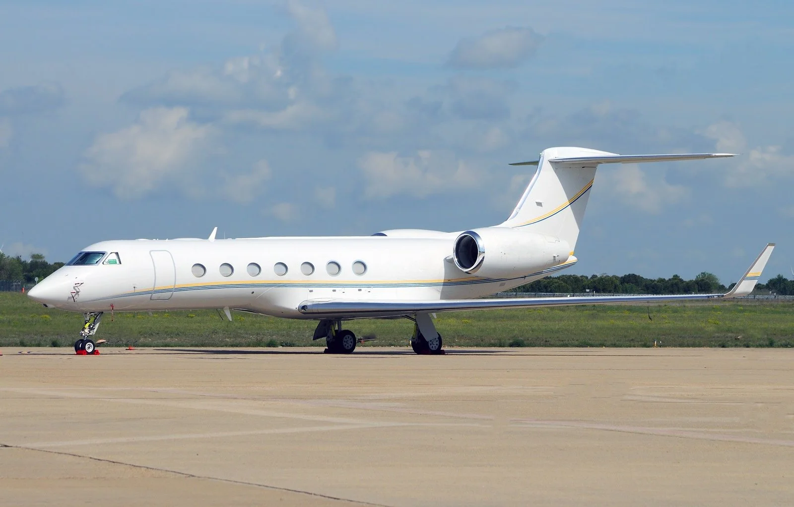 White Gulfstream G550 jet parked on an airport apron